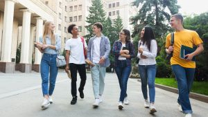 a group of college age people strolling down a street